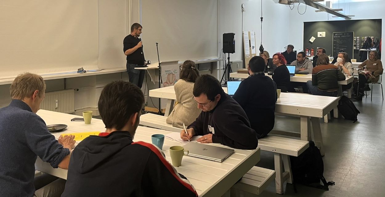 Am Nachmittag wurden die Ergebnisse des Barcamps noch einmal zusammengefasst und von den Chairs, hier Fabian Fricke, vorgetragen. Momentaufnahme während des Regionaltreffens: Abgebildet sind Teilnehmende des Barcamps an einem der Diskussionstische.