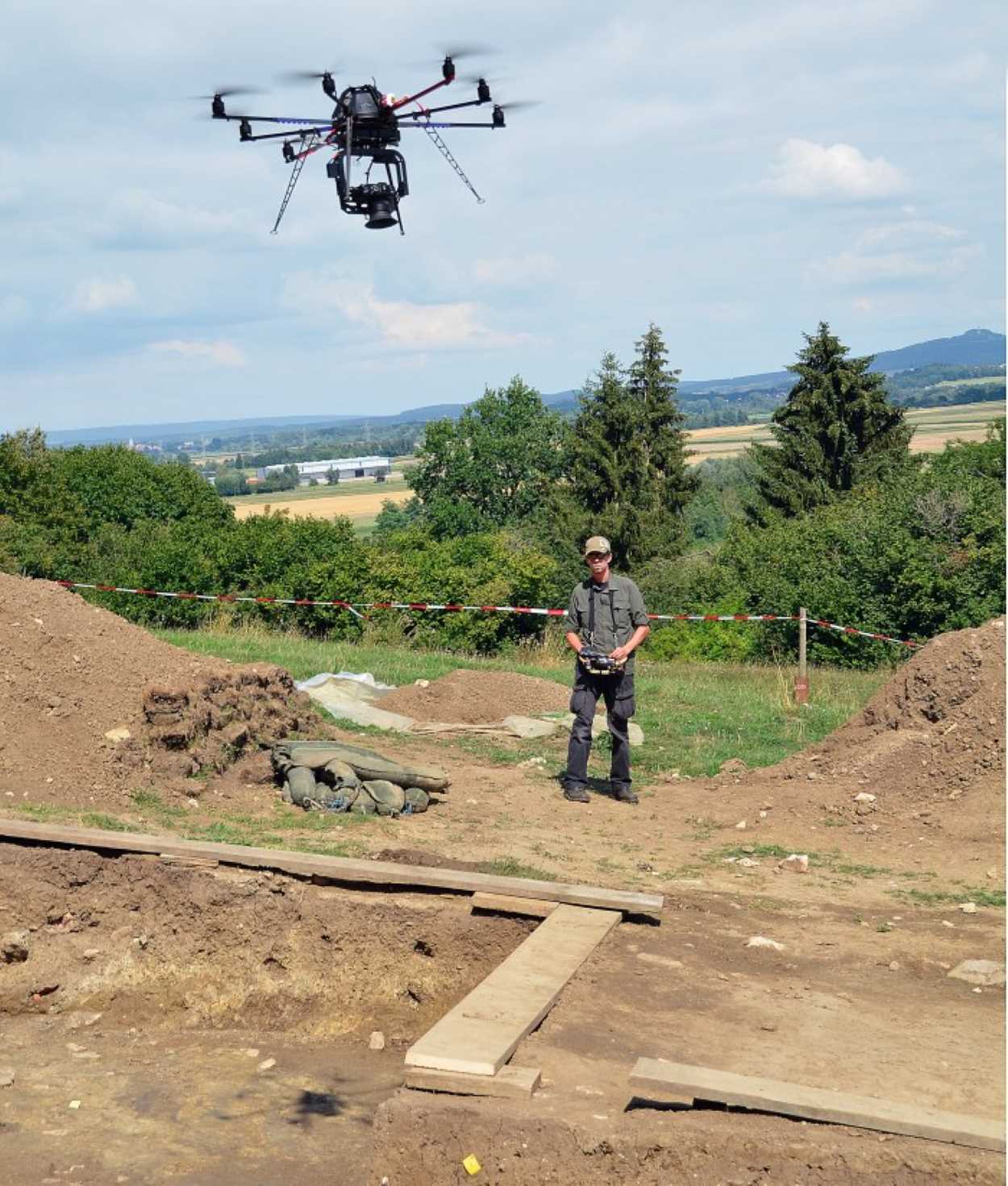 Employee controls a drone over an excavation.